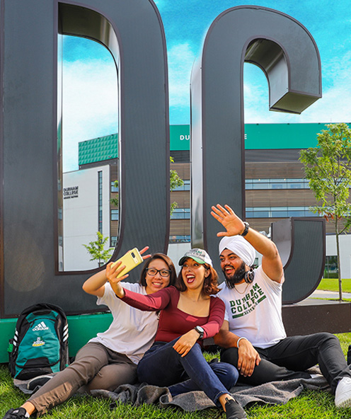Girl standing in front of the Durham College sign
